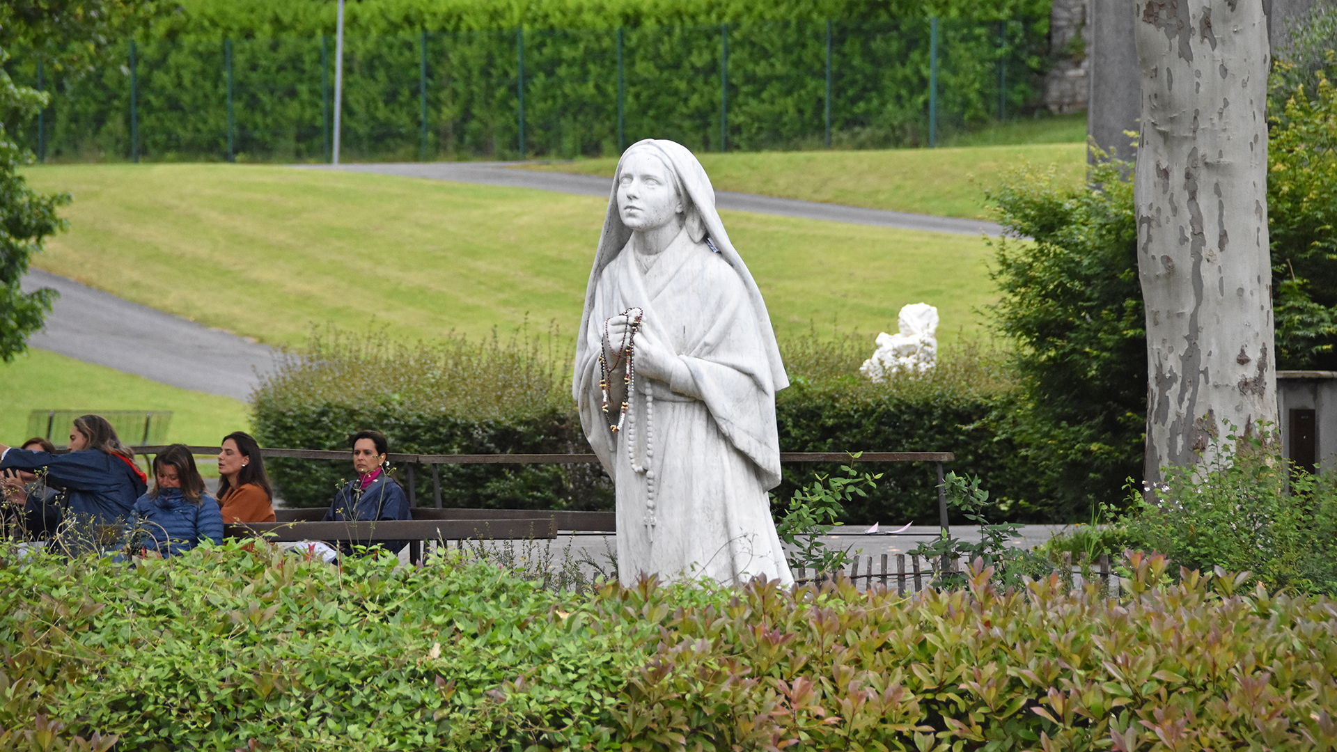 A Lourdes, 'Bernadette' observe la grotte à partir de l'autre rive du Gave de Pau | © Grégory Roth