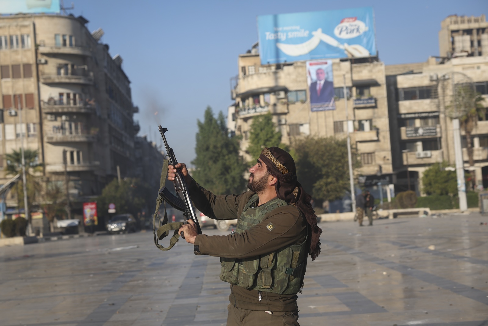 Un combattant de l'opposition syrienne tire en l'air dans le centre-ville d'Alep, en Syrie, le samedi 30 novembre 2024 | © Keystone/AP Photo/Ghaith Alsayed