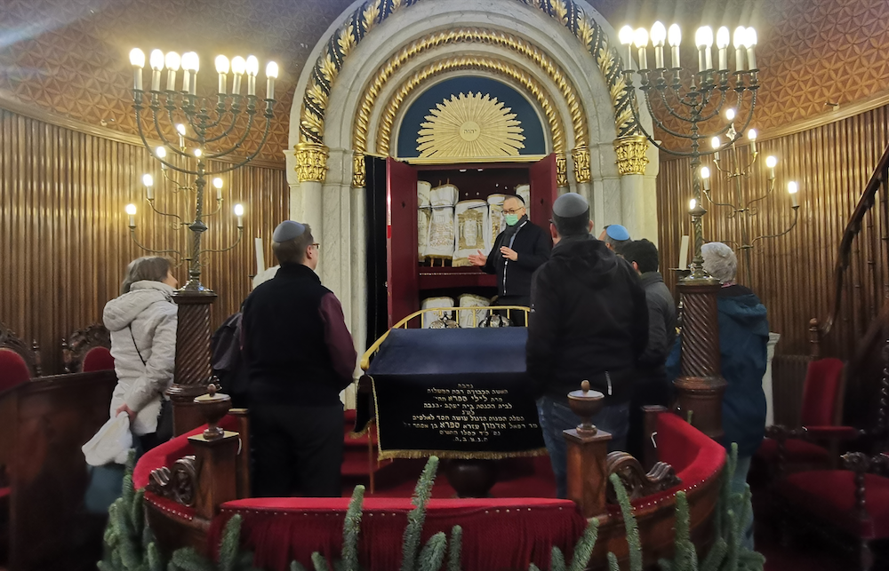 Des participant de la marche 'foi pour les droits' sont reçus dans la grande synagogue de Genève par le rabbin Eric Ackermann, le 8 décembre 2024| © Barbara Doswell 