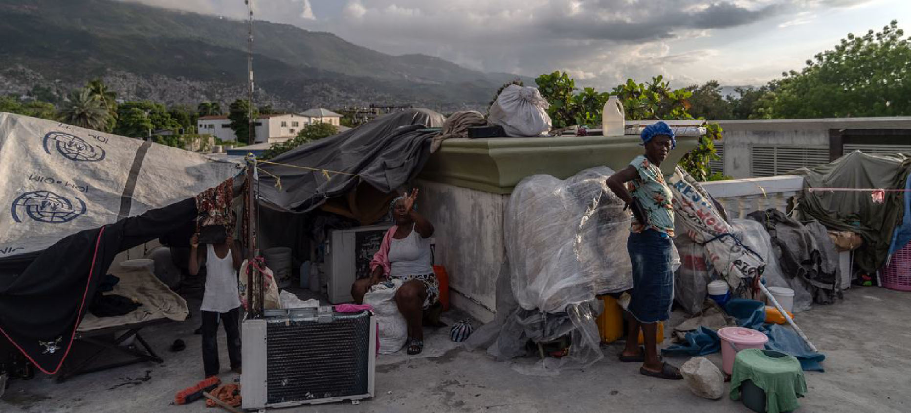 Une famille déplacée par la violence des gangs à Port-au-Prince, en Haïti, vit dans une tente sur le toit d'un ancien bâtiment gouvernemental | © UNOCHA/Giles Clarke
